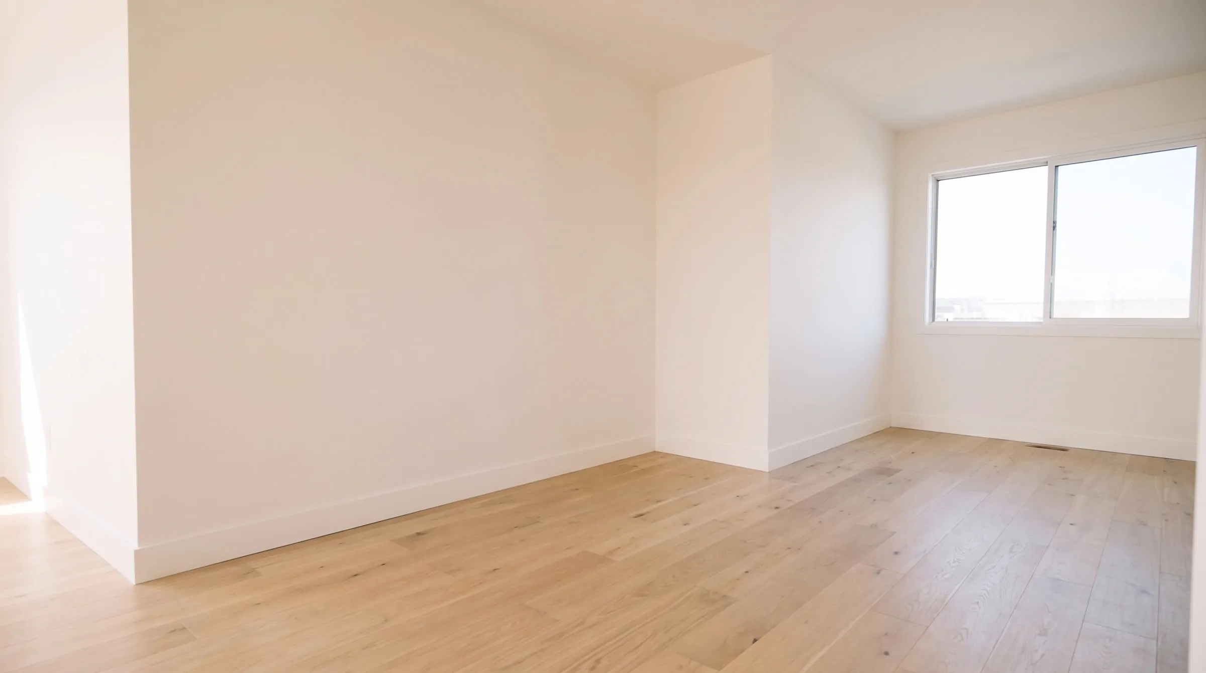 Empty new-build room painted warm white